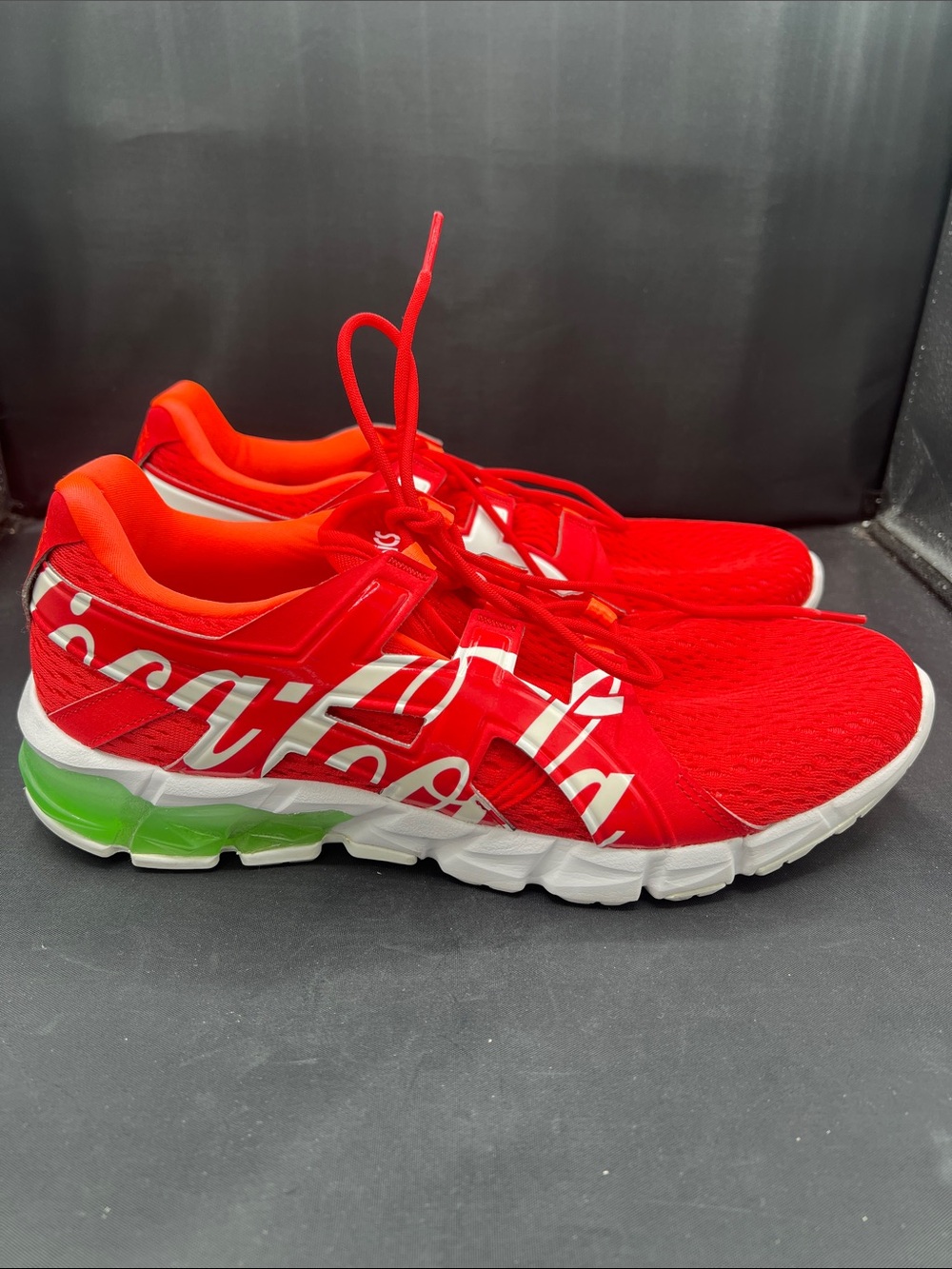 Red Athletic Running Shoes with White Script and Green Heel Accent